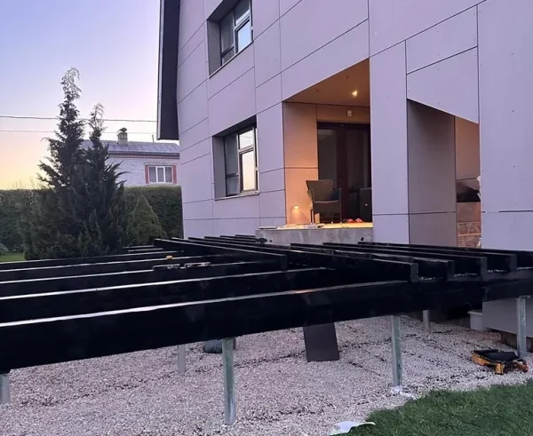 The terrace frame on a screw pile foundation in Sigulda, before the decking is installed, with a view of the house's facade